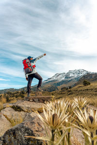Rear view of man standing on field against sky