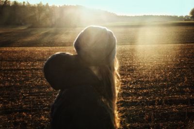 Rear view of woman standing on field