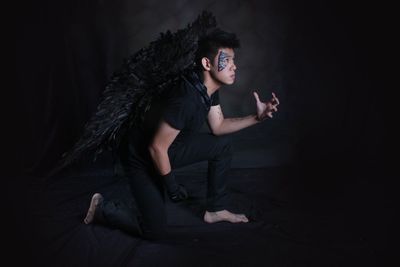 Man wearing costume against black background
