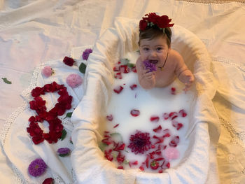 High angle portrait of cute baby relaxing on bed