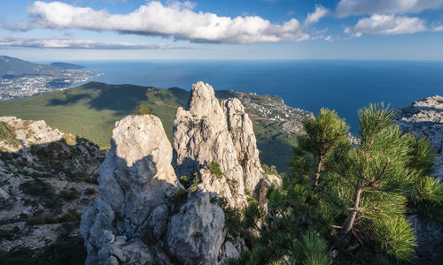 Panoramic view of rocks and sea against sky