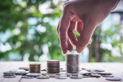 Close-up of hand holding coin stack