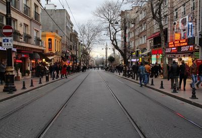 People walking on road amidst buildings in city