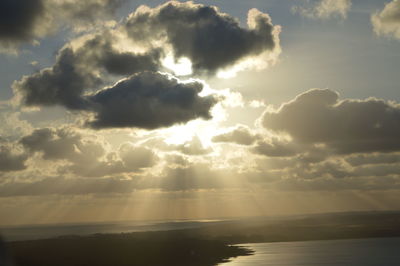 Scenic view of sea against cloudy sky during sunset