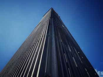 Low angle view of skyscraper against clear blue sky
