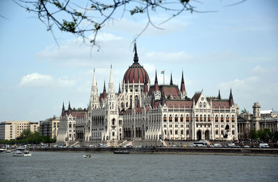 View of buildings in city against cloudy sky