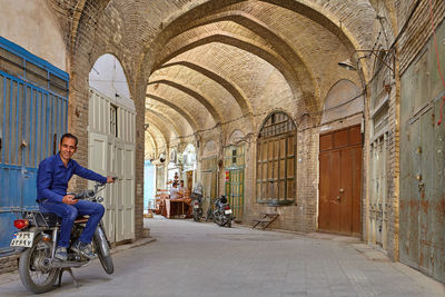 Man sitting in corridor of building