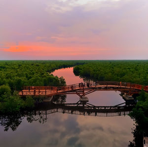 Arch bridge over river against sky during sunset