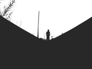 Low angle view of silhouette person standing against clear sky