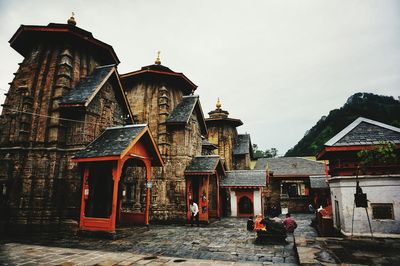 People at temple against sky