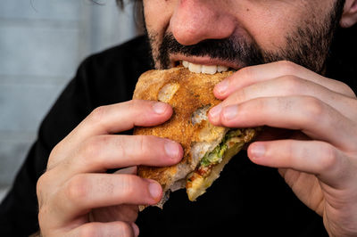 Close-up of man eating burger