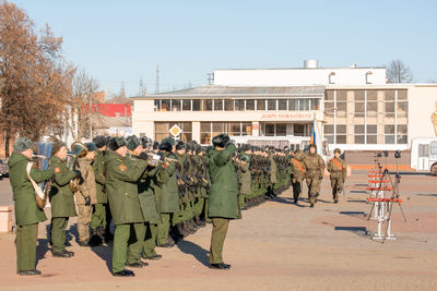 Group of people walking in city against sky