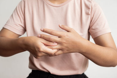 Close-up of woman holding hands over white background