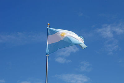 Low angle view of flag against blue sky