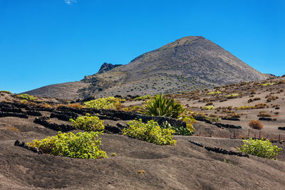 Scenic view of mountain against blue sky