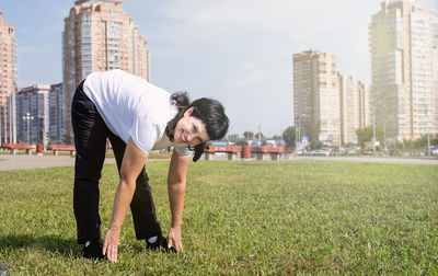 Full length of man standing on field against buildings