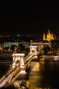 Illuminated bridge over river at night