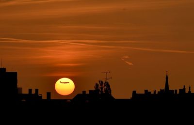 Silhouette buildings against sky during sunset