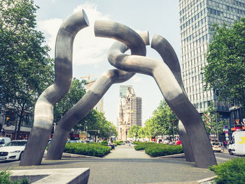 Statue in city against sky