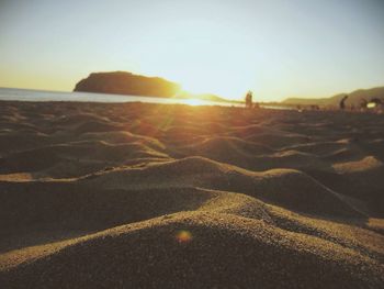 Scenic view of sandy beach at sunset
