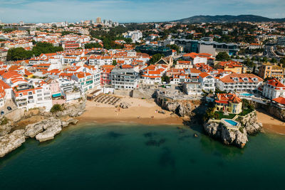 High angle view of townscape by sea against sky