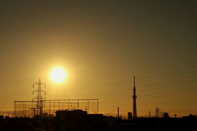 Electricity pylon against sky during sunset