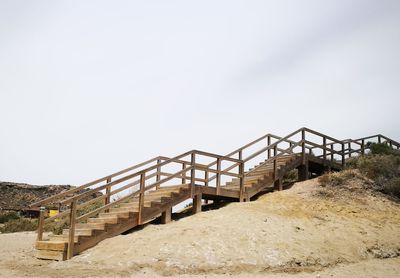 Metallic structure on beach against clear sky