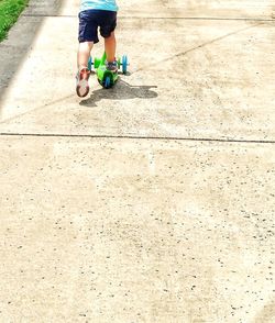Low section of boy playing with umbrella
