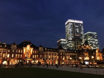 Illuminated buildings against sky at night