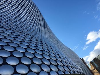 Low angle view of modern building against blue sky