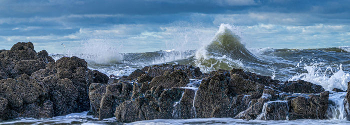 Panoramic view of sea and rocks against sky