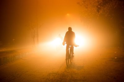 Man riding bicycle at night