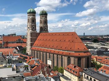 Church and buildings in city against sky 