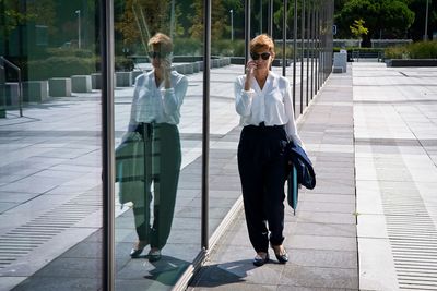 Woman walking with umbrella on glass