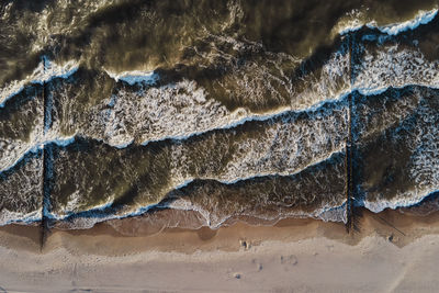 Coastline with sea waves and sand beach, top view