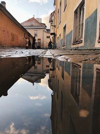 Reflection of buildings in puddle on lake