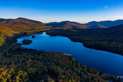 Scenic view of lake and mountains against blue sky