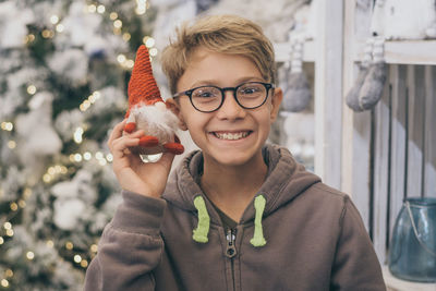 Portrait of smiling boy holding christmas decoration