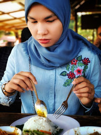 Midsection of woman holding ice cream in restaurant