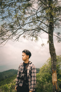 Young man looking at tree