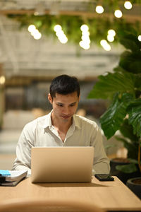 Young man using laptop at table
