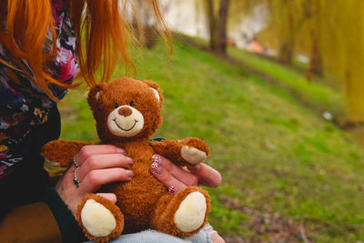 Midsection of woman holding teddy bear