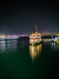 Illuminated ship by sea against sky at night