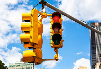 Low angle view of yellow road signal against sky