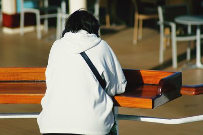 Rear view of woman standing on table