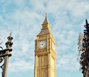 Low angle view of clock tower against cloudy sky