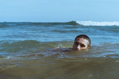 Portrait of young man swimming in sea