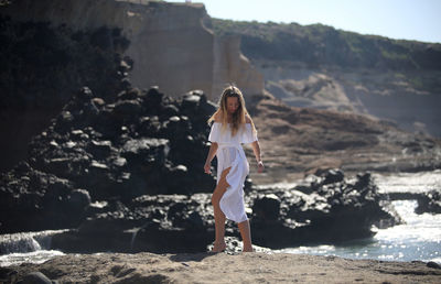 Woman standing on rock at beach