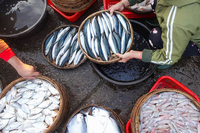 High angle view of hands preparing portions of fish at duy hai fish market in hoi an, vietnam