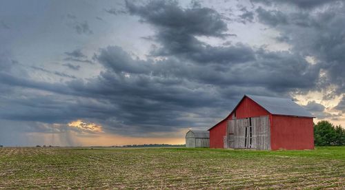 Barn on field against sky